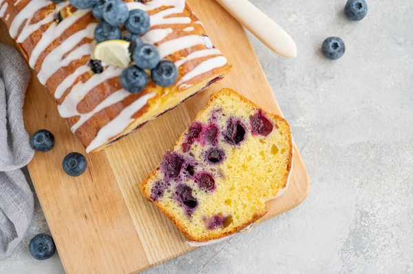 Limon kremalı limonlu yaban mersinli pasta ve tahtada gri beton arka planda bir fincan çayla taze böğürtlen. Seçici odaklanma. Boşluğu kopyala
