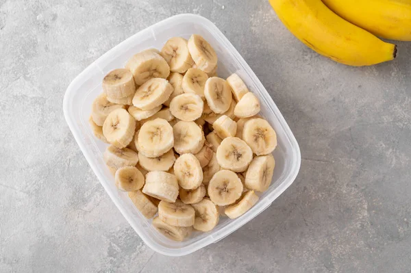 Rebanadas Plátano Congelado Recipiente Sobre Fondo Hormigón Gris Ingrediente Para — Foto de Stock