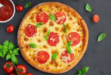 Geleneksel İtalyan pizzası Margarita ya da domates soslu margharita, mozzarella peyniri ve gri arka planda taze yeşil fesleğen. Üst görünüm, alanı kopyala