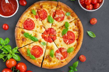 Geleneksel İtalyan pizzası Margarita ya da domates soslu margharita, mozzarella peyniri ve gri arka planda taze yeşil fesleğen. Üst görünüm, alanı kopyala