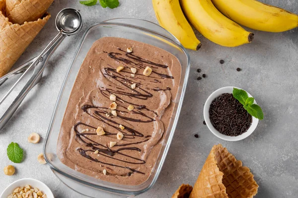 香蕉巧克力冰淇淋与巧克力釉面和坚果的灰色混凝土背景 健康食品 顶部视图 — 图库照片