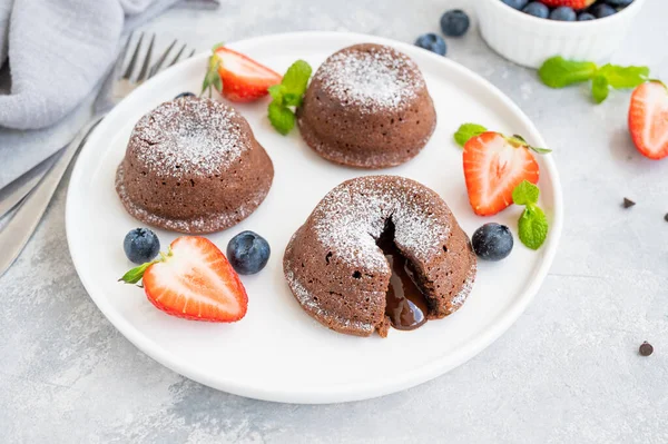 Gri arkaplanda taze böğürtlenli çikolatalı lav keki.