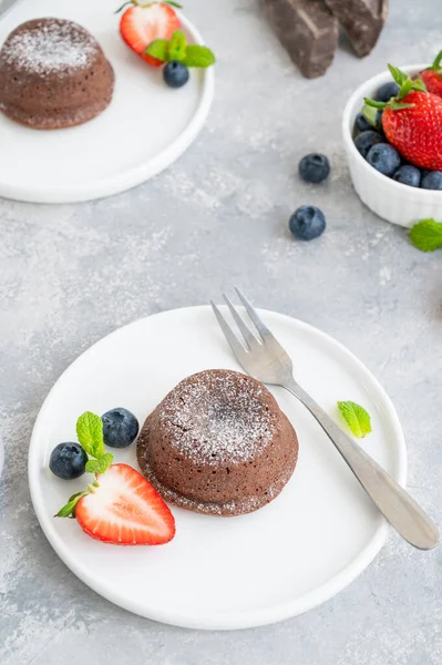 Gri arkaplanda taze böğürtlenli çikolatalı lav keki.