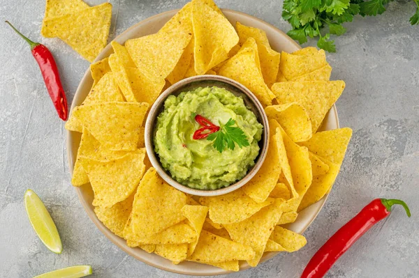 Mexican Nachos chips and dip sauces. Tortilla corn nachos chips with tomatoes salsa and guacamole. Top view