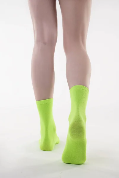 穿着绿色紧身裤和白袜的女人的腿 — 图库照片