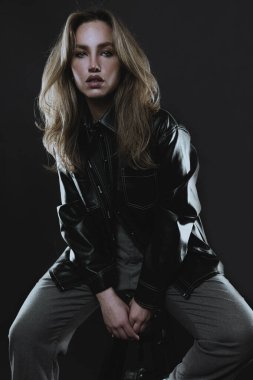 Stüdyoda poz veren uzun saçlı güzel bir genç kadın.