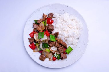 Sebzeli biftek yahnisi ve beyaz tabakta et.