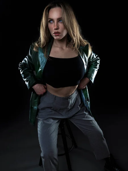 黒の背景に刀と黒のジャケットを着た美しい若い女性 — ストック写真