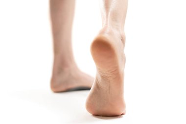 barefoot woman legs against white background, copy space 