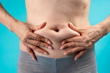 partial view of overweight female belly with fat 