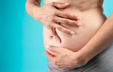 partial view of pregnant woman, hands on belly 