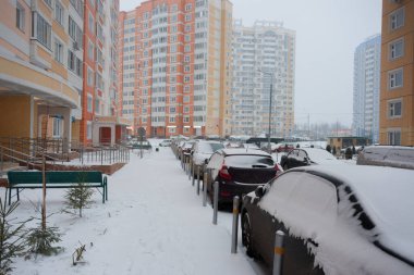Şehirdeki arabalar ve yollar karla kaplı.