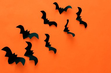 Cadılar Bayramı konsepti, turuncu arka planda siyah kağıt yarasalar