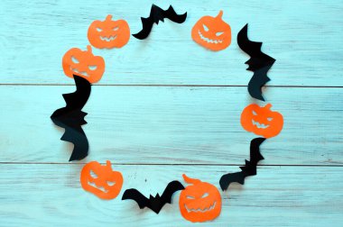 Helowin kavramı, siyah yarasalar ve kağıttan yapılmış turuncu balkabakları tahta arka planda yatar.