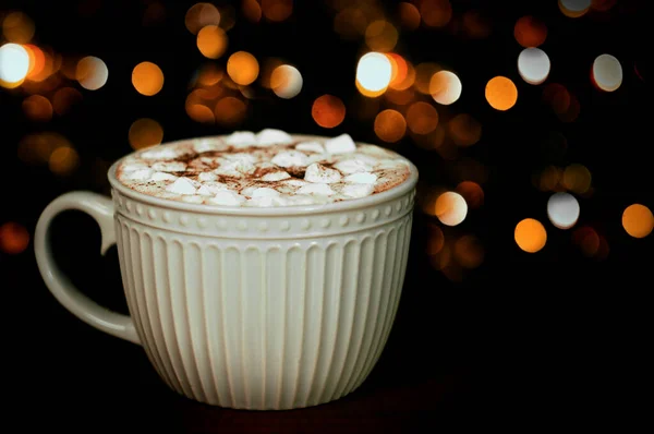 large cup of hot cocoa or chocolate with blurred bokeh in the background, selective focus