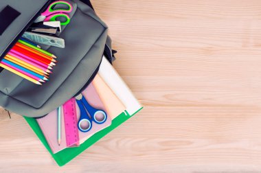 school backpack with notebooks, pens, pencils and other school supplies with space for text. High quality photo