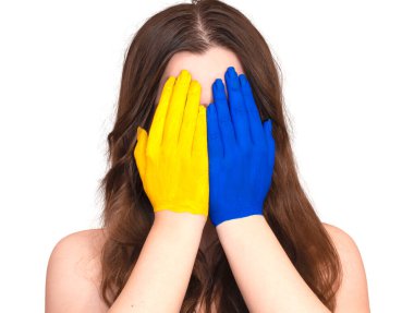 Ukrayna ulusal bayrağının renklerine boyanmış kadınların elleri yüzü beyaz arka planda izole bir şekilde kaplıyor. Yüksek kalite fotoğraf