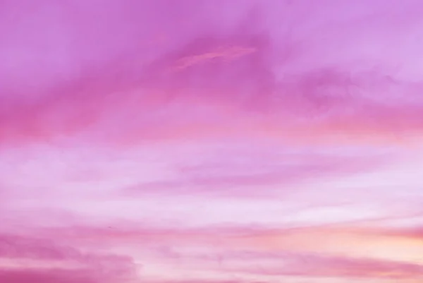 Early morning light sky before sunrise. Soft purple, pink and orange light on the horizon. Thin clouds in natural sky with colorful pastel tone colors for background.