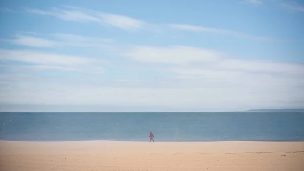 a sad man alone walking on the beach