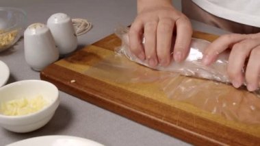 Kadınların elleri sığır filetosunu kabuğa sarar.