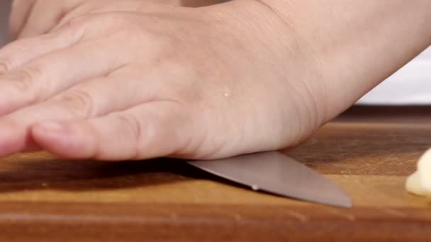 Σεφ συνθλίβει σκόρδο με μαχαίρι πίνακα κουζίνα — Αρχείο Βίντεο