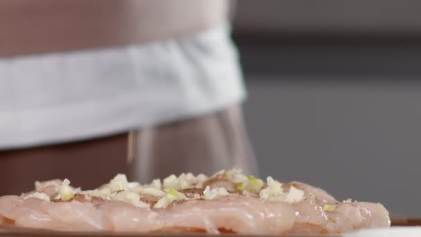 Повар посыпает филе мелко нарезанным чесноком — стоковое видео