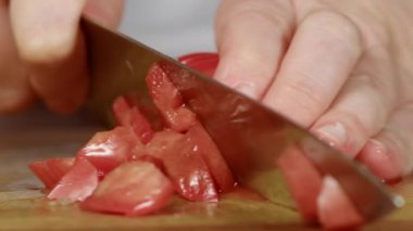 Kadın olgun domates dilimliyor.