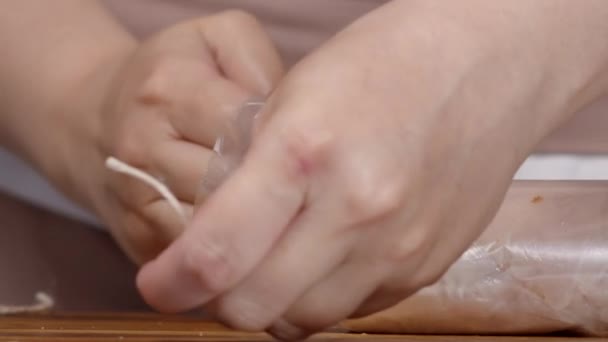 Frauenhände binden Ärmel mit Hühnerrolle — Stockvideo