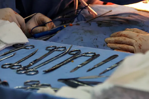 手术器械表和背景下进行外科手术的医生 — 图库照片