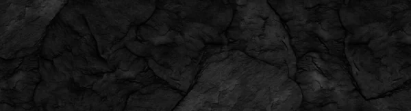 Panorama dark gray stone background with copy space. Black grunge banner with rock texture.The texture of the stone wall.