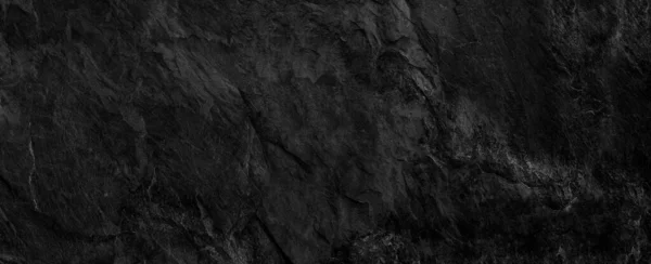 Panorama dark gray stone background with copy space. Black grunge banner with rock texture.The texture of the stone wall.