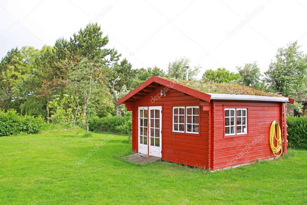 red garden shed with green roof