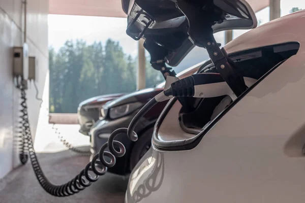 Ön tarafta elektrikli araba şarj ediliyor.