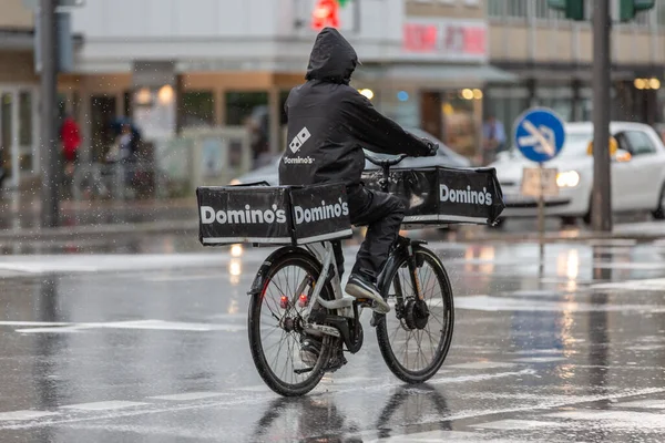 Domino 'nun pizza teslimatçısı yağmurda bisikletli.