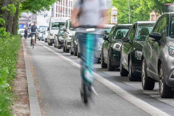 an e-scooter on the bike path overtakes cars in a traffic jam