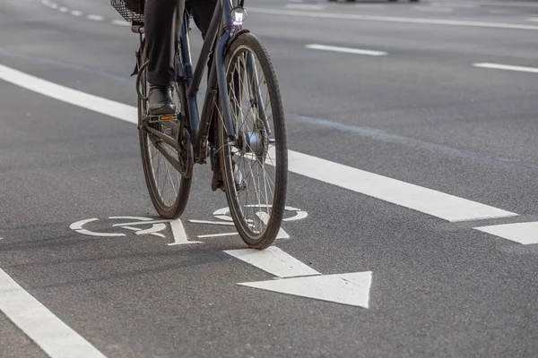 Bisikletçi bisiklet yolunda piktogramla geziyor.