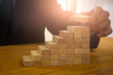 Business man gambling placing wooden block. Business concept  investment target and growth success process background present financial information planning, risk and marketing strategy analysis.