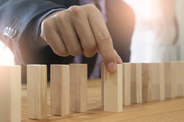 Business man gambling placing wooden block. Business concept  investment target and growth success process background present financial information planning, risk and marketing strategy analysis.
