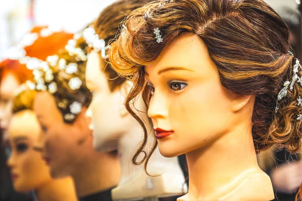 Capelli parrucca testa parrucchiere righe manichino in mostra su alcuni manichini in un negozio — Foto Stock