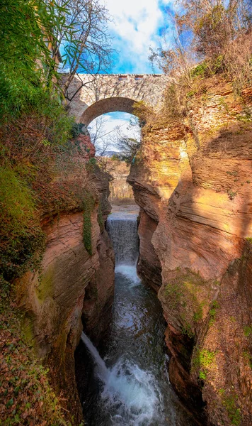 Kaňon s skalním mostem barevné krásné oranžové bez lidí s jasnou modrou oblohou vertikální pozadí Ravine Orrido Ponte Alto v Trentu - region Trentino Itálie — Stock fotografie