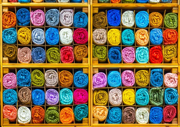 Tailor store colorful textile texture rolls of fabric on shelves background — стоковое фото