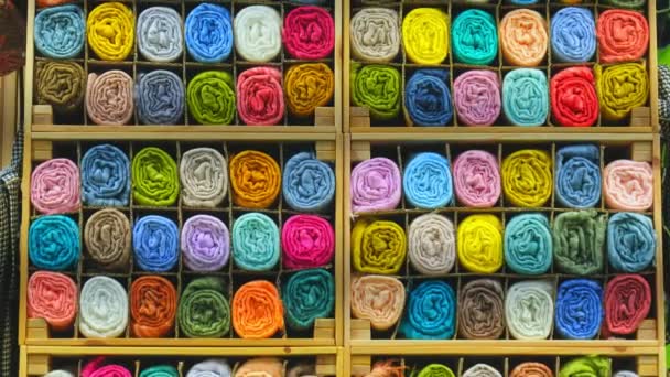 Tailor store colorful textile texture rolls of fabric on shelves background — стоковое видео