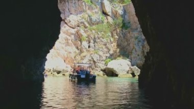 a small boat stop in one of the sea caves in the archipelago of the Tremiti Islands in the Gargano in Puglia , Italy