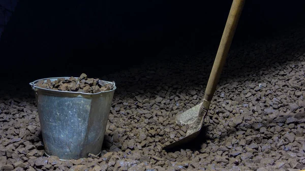 Setumpuk batubara coklat, seember batubara dan sekop dengan latar belakang gelap. Pemanasan di musim dingin, bahan bakar untuk pemanasan — Stok Foto