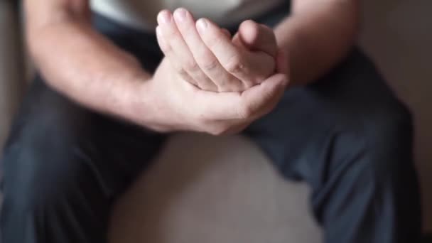 En äldre man gnider och masserar ömma fingrar leder med symtom på smärta i artrit, artros, periartrit. Användning för hälso- och sjukvårdskoncept och läkemedel — Stockvideo