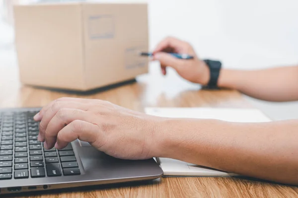 The parcel receiving staff checks the delivery address and type it into the computer and check on the box to make it right