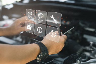 Serviceman working onsite use tablet check service list for maintenance of car with the engine room in the background,Car service concept