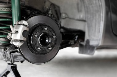 Close up Rear brake caliper and disk with  jack kit of car service tool  for check brake pads and brake disc thickness, Initial inspection by yourself of car service concept