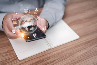 Akıllı telefon ekranı ve ofisteki not defterindeki sanal ekran detaylarına dokunan işadamı, sınırları olmayan internet dünyasında bağlantı teknolojisiyle yaratıcı fikirler kullanıyor.