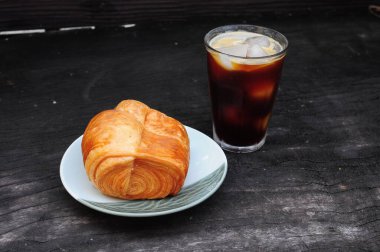 Tren kruvasanı ve buzlu sade kahve.